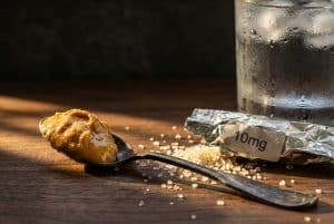 Spoon with peanut butter and gummy wrapper illustrating safety tips for taking edibles on empty stomach